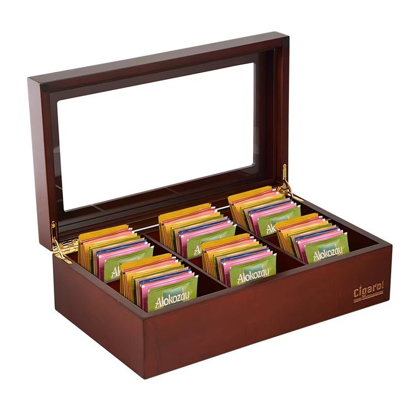 Wooden tea bag storage box with multiple sections and a clear glass lid, organized with colorful tea bags.