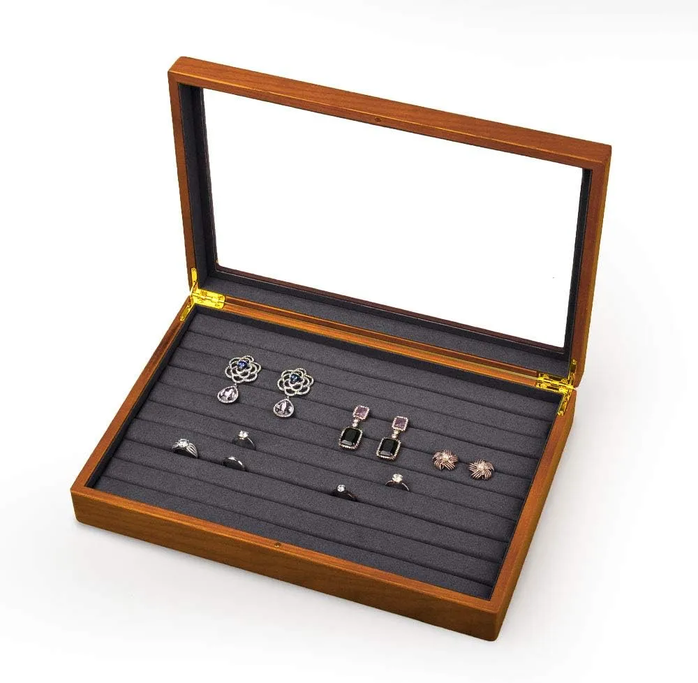 Wooden jewelry box with a clear glass lid and multiple padded slots for organizing rings and earrings.