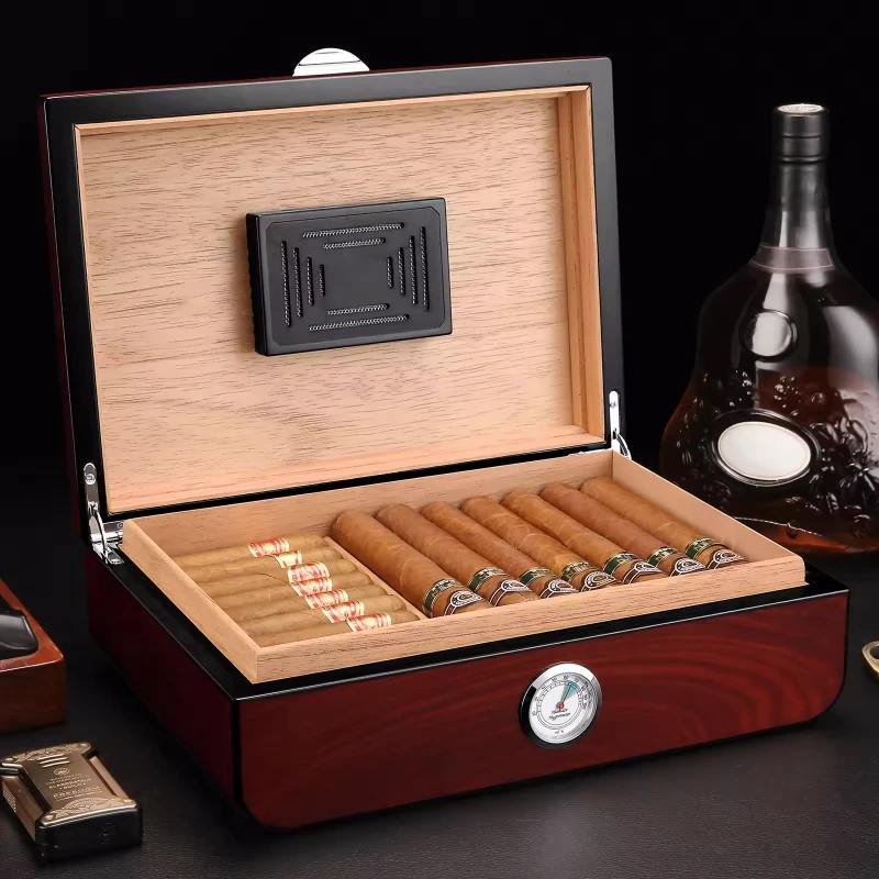 Humidor de charutos de madeira aberto com charutos e higrómetro